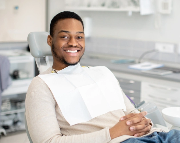 Smiling male patient relaxed in dental chair at modern dental office clinic