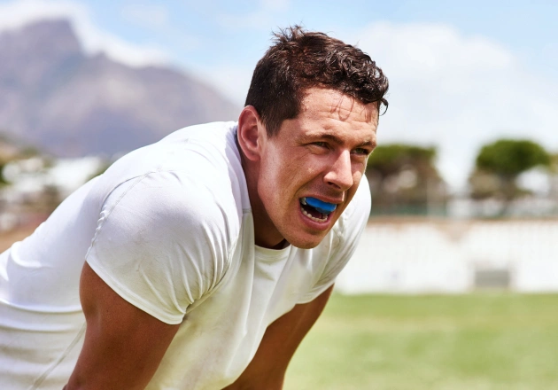 Man in white shirt appearing energetic or excited outdoors on sports field