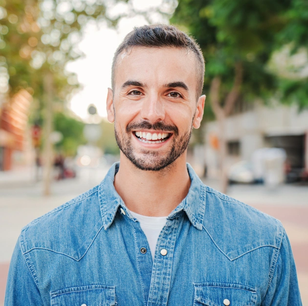 Smiling male dental professional in denim shirt outdoors at Escondido Family Dental Care.