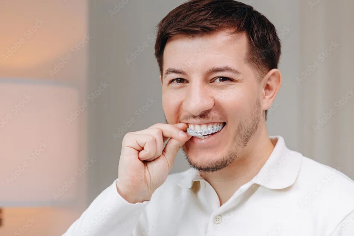 Happy man using Invisalign clear aligners to achieve a straighter smile